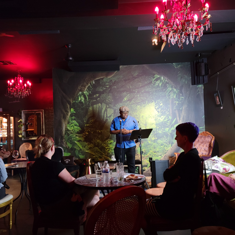 Man in blue shirt reading his new poem