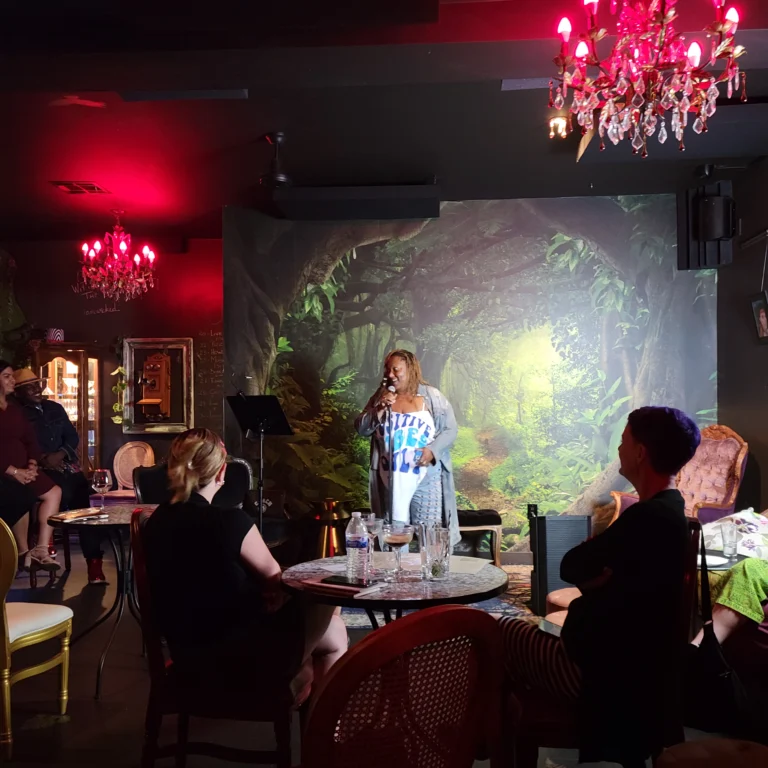 Woman in a "positive vibes only" shirt reciting her poem